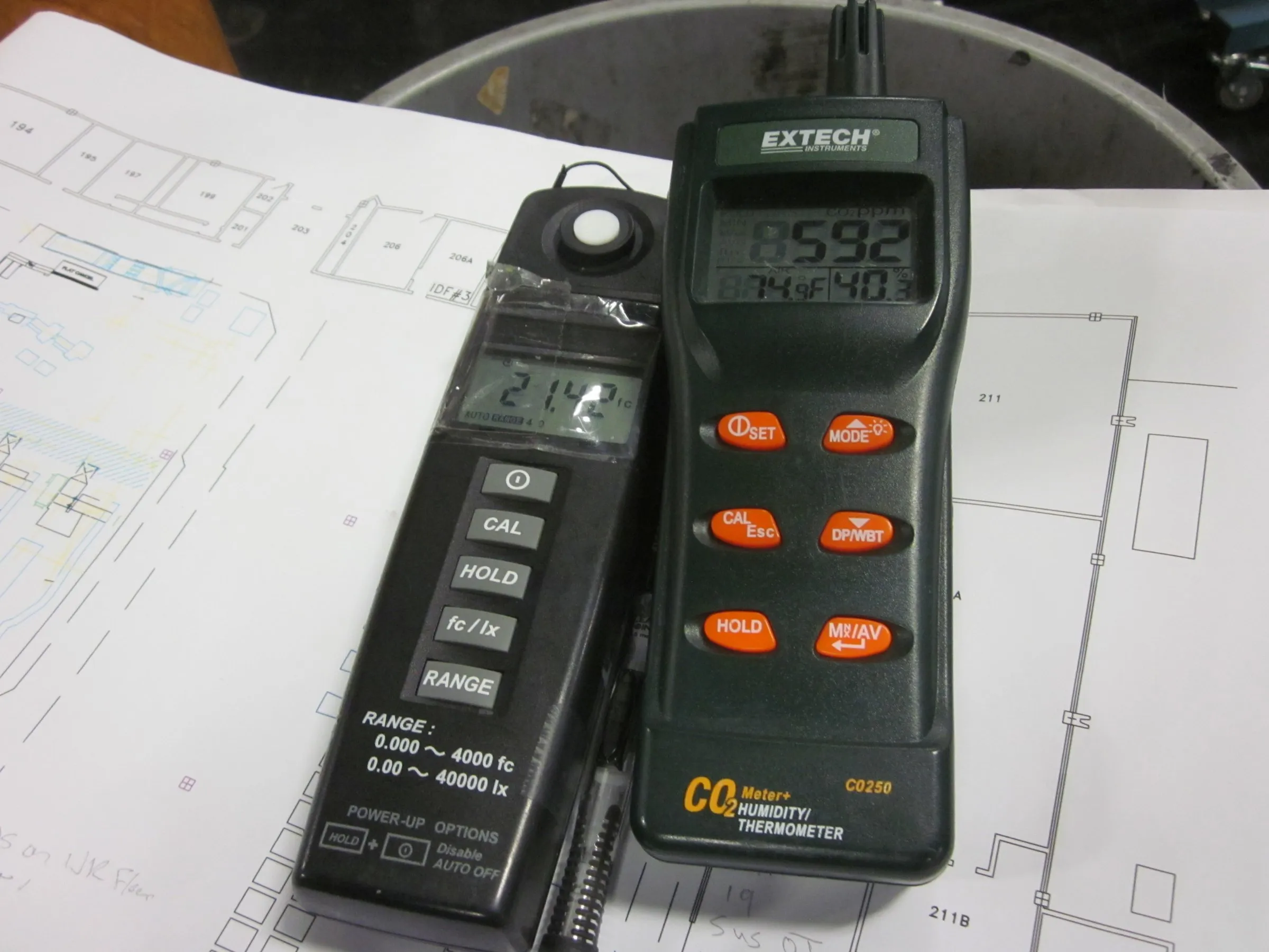 Light and power meters on a set of building drawings during a site survey